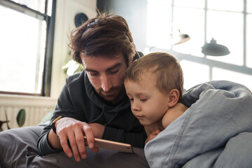 Father and son watching cartoons on the phone