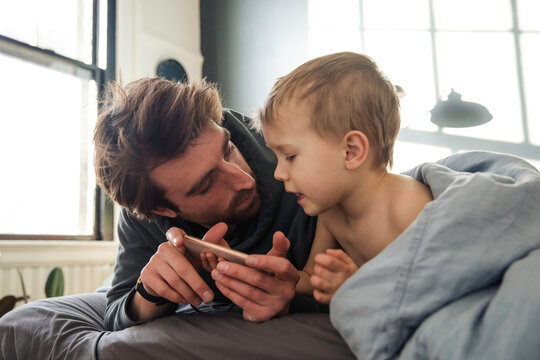 Father and son watching cartoons on the phone