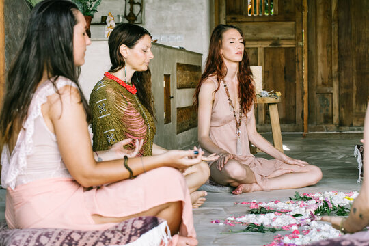 Women Meditating Around Flower Mandala