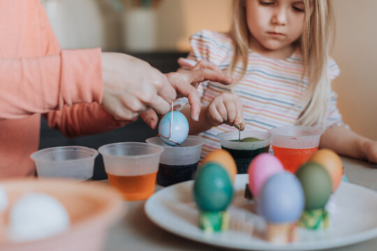 Adorable Blonde Girl Dyeing Easter Eggs