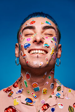 Naklejki Smiling man with stickers on face in studio