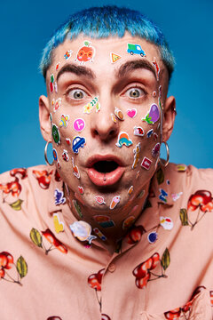 Naklejki Expressive man with stickers on face in studio