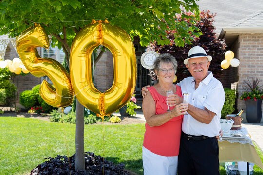 Senior Citizen Couple Champagne Toast at Golden 50th Wedding Anniversary