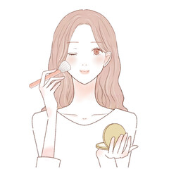 パウダリーファンデーションをメイクブラシで顔に塗る女性