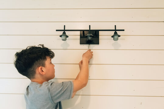 Boy changing light bulbs. 