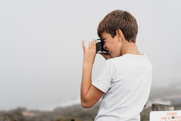 boy taking photo of seaside 