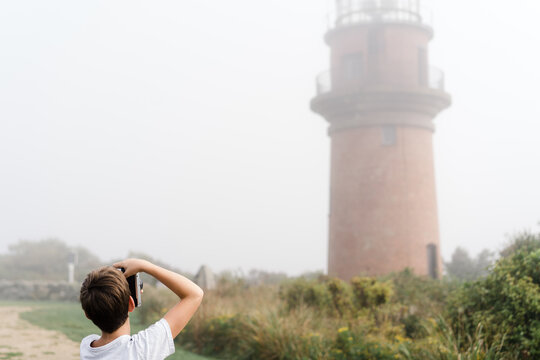 boy taking photo of lighthouse