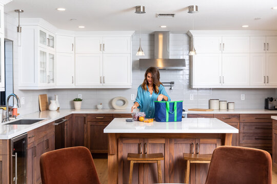 Woman Organizes Groceries in Kitchen