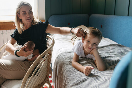 Beautiful mother with small children in a cozy modern interior.