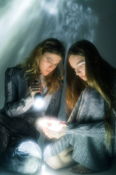 Calm women in dark studio with glowing flashlight