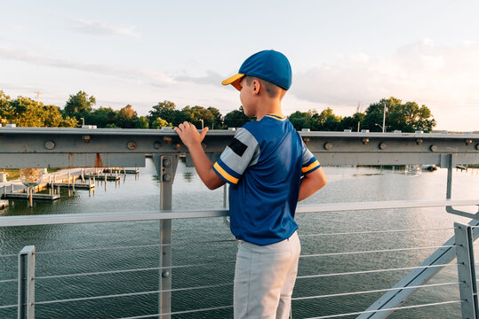 Back of a boy looking down into the water. 