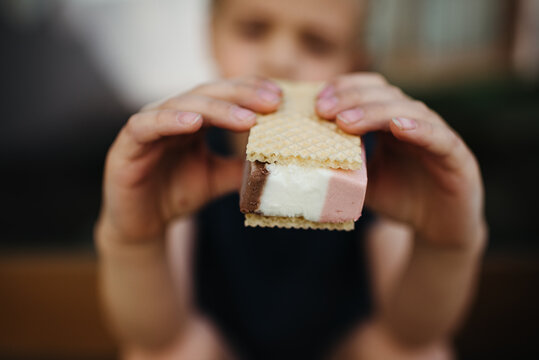 Close up of a young boy eating ice cream outdoors