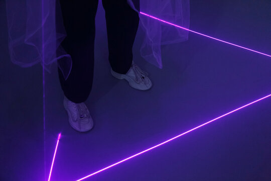 Faceless person standing on floor with neon lines