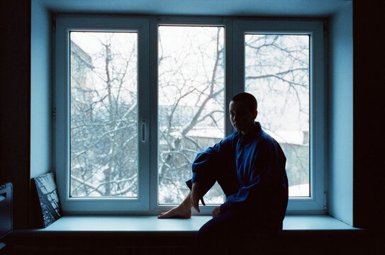 Woman sitting at windowsill. 