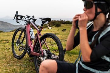 Cyclist resting near electric bike in highlands 