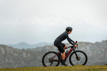 Sportive bicyclist working out on e bike in mountains 