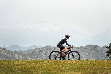 Sportive bicyclist working out on e bike in mountains 