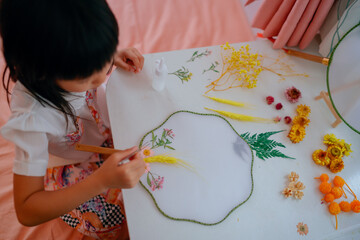 Asian kid making dried flower fan decoration DIY