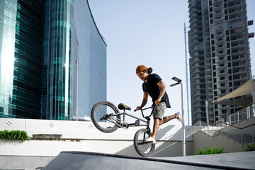 Portrait of a Young Tattooed man doing trick on BMX.