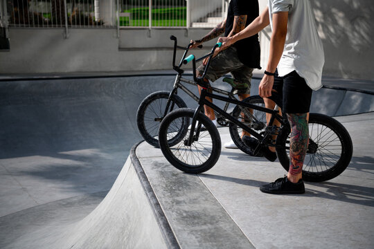 Two Young Tattooed Men On BMX Bikes.