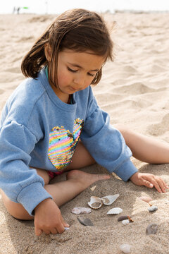 little girl Hunts For Shells On A Beach
