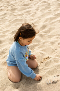 little girl Hunts For Shells On A Beach