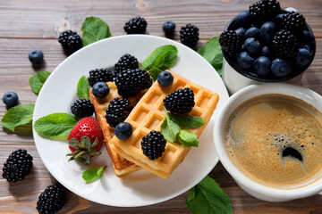 Waffles with blueberries, strawberry and blackberries.