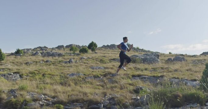 Male athlete running through the forest. An active young woman having an intense jogging workout.