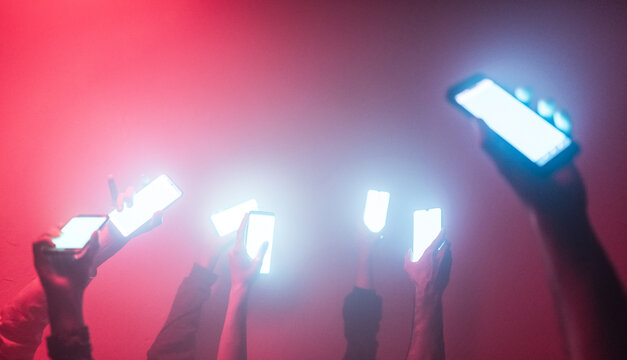 Hands holding iluminated cell phones