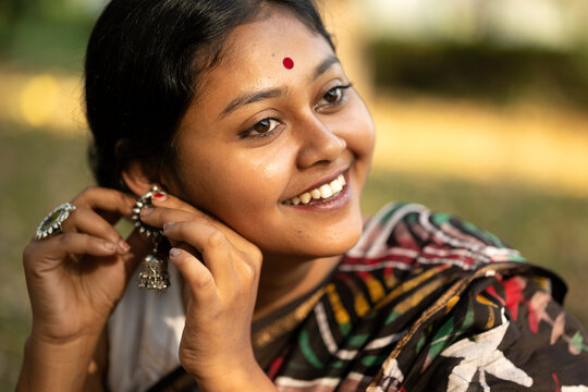 Young Indian woman fixing earring 
