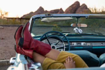 Red Cowboy boots in Backseat of Convertible car on Road Trip 
