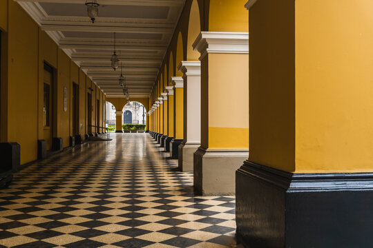 path with black and white tiles with yellow columns on the side of the Santa Rosa passage in the historic center of Lima Peru
