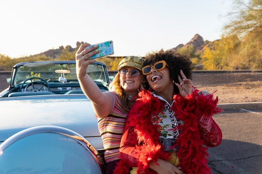 Young Happy Friends Taking Selfie with Vintage Car with fuzzy dice 