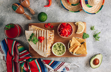 Grilled quesadillas on wooden board and with salsa and guacamole on stone background. Mexican cuisine concept Quesadilla wrap with chicken and corn.