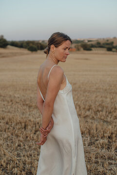 Woman in white turning back while standing on a field