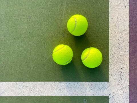 Tennis balls on green and purple court 