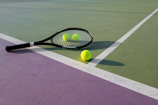 Tennis racket and ball on a colorful court
