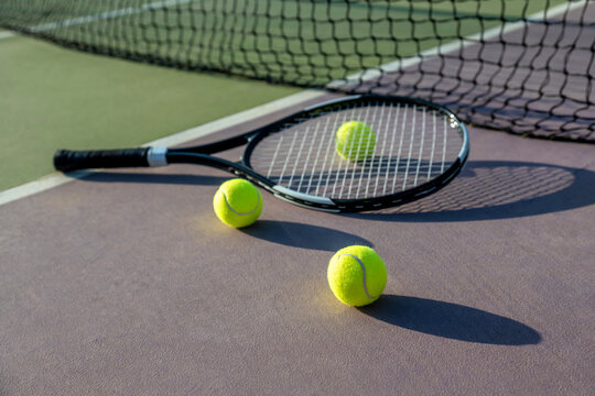 Tennis racket and ball on a colorful court