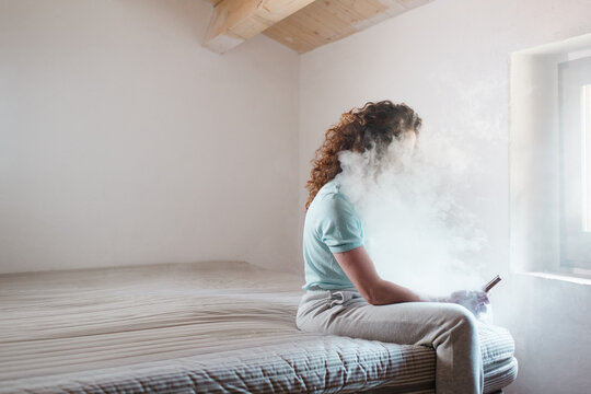 Unrecognizable woman inside smoke cloud