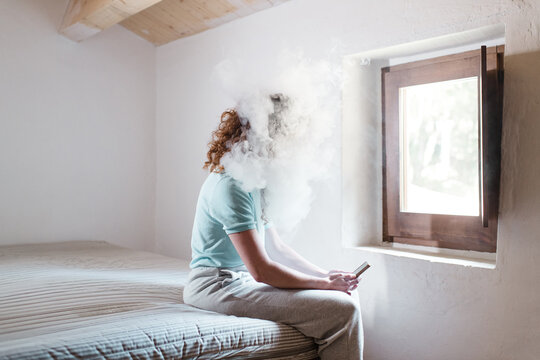 Woman using phone with a smoke cloud