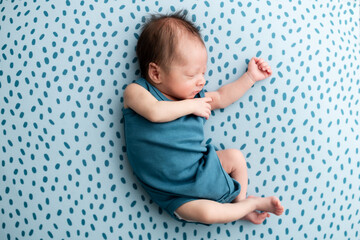 Baby sleeping on blue pattern