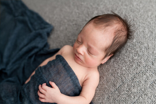 Baby in blue on blanket