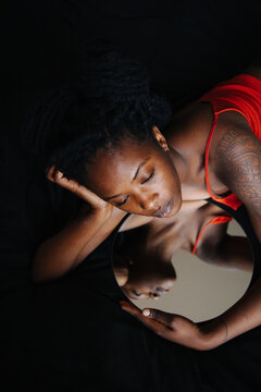 Reclined black girl reflected in the mirror