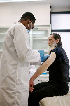 Physician doing vaccine procedure to man 