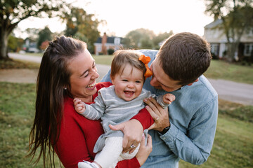 Young Mom and Dad Being Playful With Their Small Daughter
