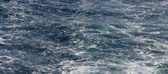 Turbulent flow of a boat wake. Sea wave. The yacht sails, leaving behind a trail and waves.