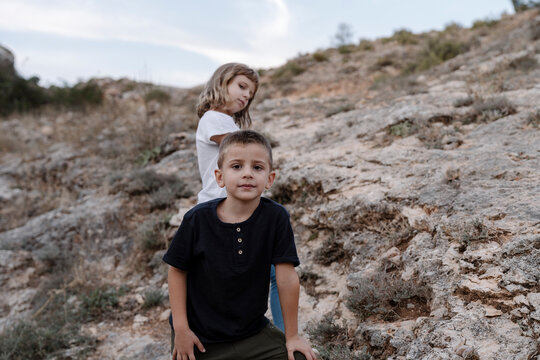Portrait of two kids standing posing for the camera outdoors