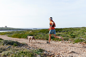 Man running with his dog on a coastal trail