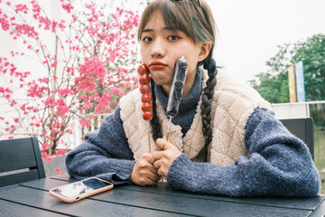 Young Asian female holding candied haws