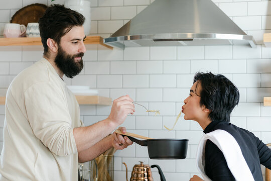 Couple Eating Pasta Together in Kitchen